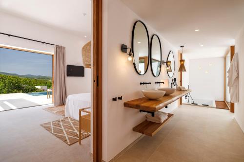 a bathroom with two sinks and a mirror at Can Lluc Suites & Villas Ibiza's Peaceful Getaway in Sant Rafael de Sa Creu