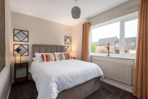 a bedroom with a bed and a large window at WORCESTER Fabulous Cherry Tree Mews self check in dogs welcome , 2 double bedrooms ,super fast Wi-Fi, with free off road parking for 2 vehicles near Royal Hospital and woodland walks in Worcester