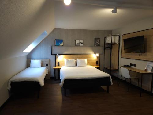 a hotel room with two beds and a television at ibis Creil Sur Oise in Villers-Saint-Paul