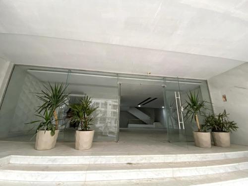 a glass building with three potted plants in it at شقة فندقية 108 in Cairo