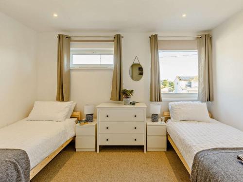 two beds in a room with two windows at 2 bed in Brixham 83741 in Brixham