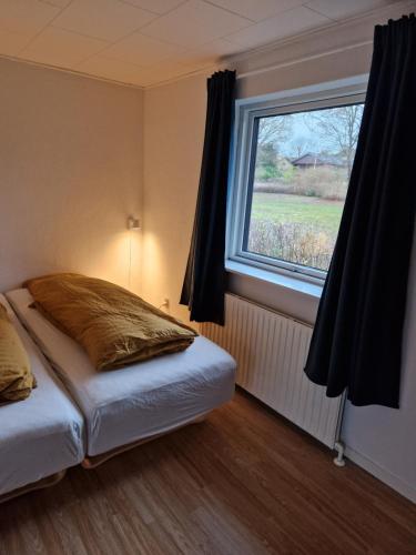 a bedroom with a bed with a large window at Lille bo in Silkeborg