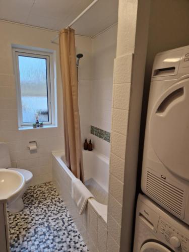 uma casa de banho com uma banheira, um WC e um lavatório. em Lille bo em Silkeborg