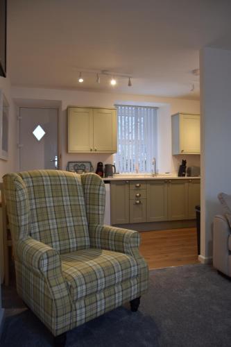 a living room with a couch and a kitchen at Bobtail Cottage by Woodland Park in Staveley
