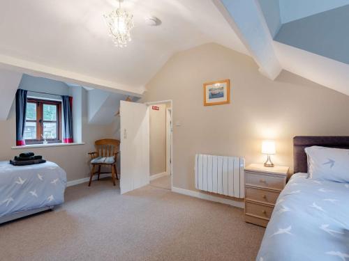 1 dormitorio con 1 cama, 1 mesa y 1 silla en 2 bed in Tywyn 83956, en Abergynolwyn