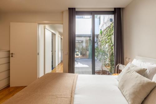 a bedroom with a bed and a large window at Yellow Lodge - Minho's Guest in Braga
