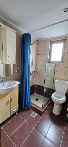 a bathroom with a toilet and a shower and a sink at North Bay Apartments in Rhodes Town
