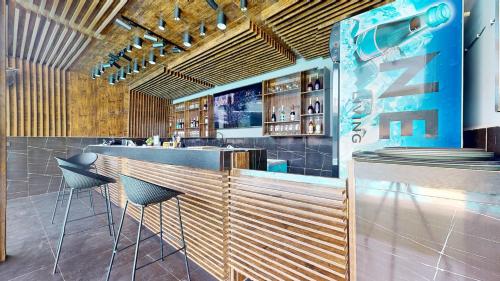 a restaurant with a bar with stools in it at YANNA APARTMENT BY KHALIQUES in Abuja