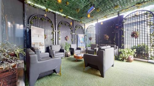 a waiting area with chairs and plants in a room at YANNA APARTMENT BY KHALIQUES in Abuja