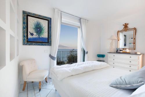 a bedroom with a bed and a window and a chair at Amore Rentals - Villa Giada in Sorrento