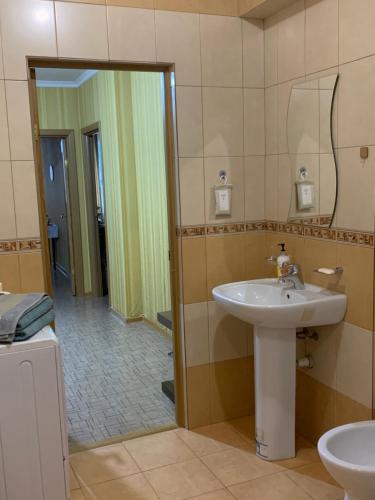 La salle de bains est pourvue d'un lavabo et d'un miroir. dans l'établissement Квартира в центре столицы!, à Astana