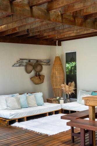 a living room with two beds and a wooden ceiling at Orixás Residence in Morro de São Paulo