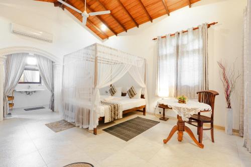 sypialnia z łóżkiem z baldachimem i stołem w obiekcie Villa Jungle & Wiener w mieście Habaraduwa Central