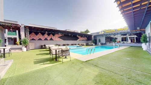 a swimming pool with tables and chairs in a building at YANNA APARTMENT BY KHALIQUES in Abuja