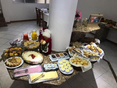 a table with many different types of food on it at Pousada Rota do Sol Bombinhas suítes com café e sem limpeza diaria in Bombinhas