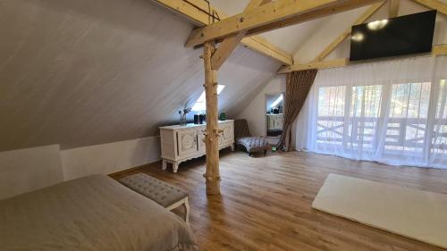 um quarto com uma cama e uma televisão num sótão em Conacul Radacinilor em Petroşani