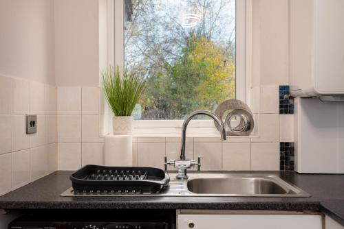 encimera de cocina con fregadero y ventana en WORCESTER Fabulous Cherry Tree Mews self check in dogs welcome by prior arrangement , 2 double bedrooms ,super fast Wi-Fi, with free off road parking for 2 vehicles near Royal Hospital and woodland walks, en Worcester