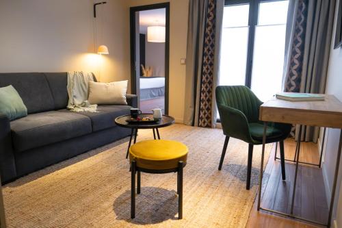 a living room with a couch and a table and chairs at Les Demeures de Varennes, BW Signature Collection in Varennes-Jarcy