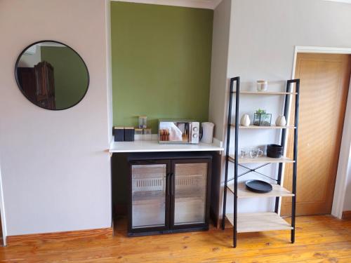 a room with a shelf and a mirror at Jacobsons Guesthouse in Bloemfontein