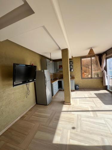 a living room with a tv and a kitchen at Auberge guest house imsouane n°5 in Imsouane