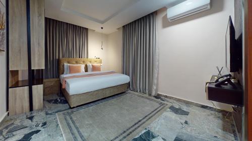 a hotel room with a bed and a television at YANNA APARTMENT BY KHALIQUES in Abuja