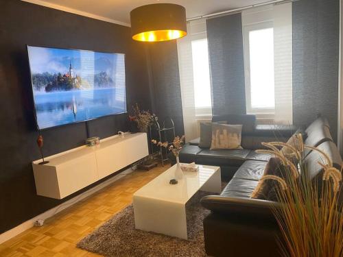 een woonkamer met een bank en een grote flatscreen-tv bij Schöne 2 Zimmer Wohnung in Stuttgart-West in Stuttgart