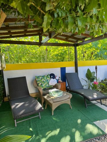 two chairs and a table on a patio at Tropicoco Pool House Steps From The Beach in Puerto Nuevo