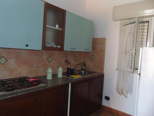 a kitchen with blue cabinets and a sink and a stove at Residence La Conchiglia in Lampedusa