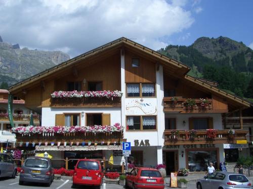a building with cars parked in front of it at Chalet Karin in Arabba