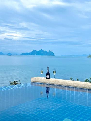 a bottle of wine and two glasses in a swimming pool at Stunning 5 bedrooms Villa with Panoramic Sea View in Por Bay