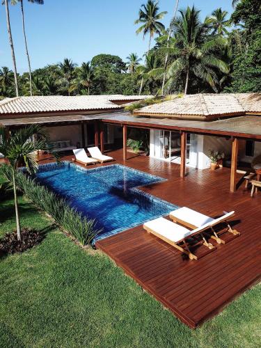 a house with a swimming pool with chairs on a deck at Orixás Residence in Morro de São Paulo