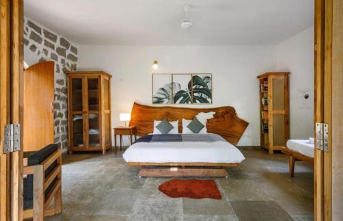 a bedroom with a bed with a wooden headboard at Jungle stay by Bilwa Estate in SanivÄrsante