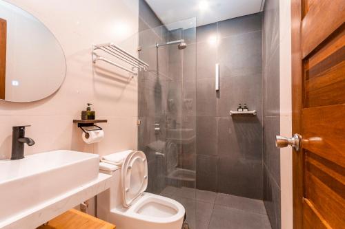 a bathroom with a shower and a toilet and a sink at Molly Resorts in Puerto Galera