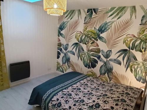 a bedroom with a bed with a floral wallpaper at logement entier avec garage. in Rieux