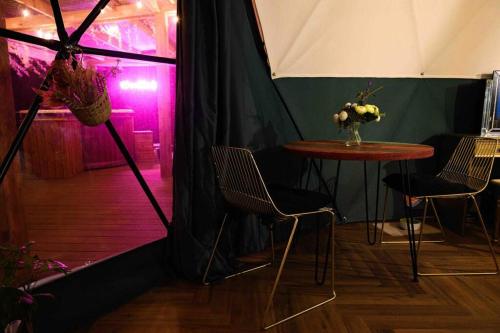 uma tenda com uma mesa e cadeiras e uma luz roxa em Hillside Haven - (Luxury Geodome) em Portpatrick