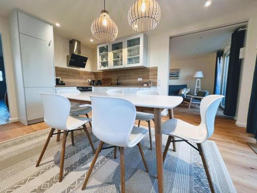 een keuken en eetkamer met een witte tafel en stoelen bij Ferienwohnung-An-t-Osterdiek in Neßmersiel