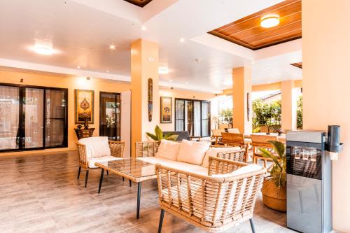 a lobby with wicker chairs and a table at Molly Resorts in Puerto Galera
