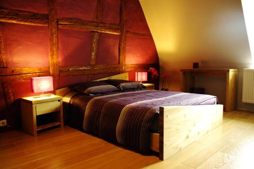 um quarto com uma cama grande e uma cabeceira em madeira em Gîte chez Val et Mat em Ribeauvillé
