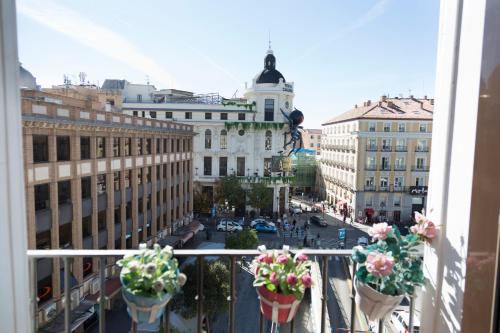 マドリードにあるPuerta del Solの花鉢付きのバルコニーから市街の景色を望めます。
