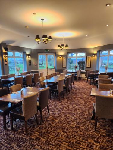 - une salle à manger avec des tables, des chaises et des fenêtres dans l'établissement Red Lion Inn & Motel, à York