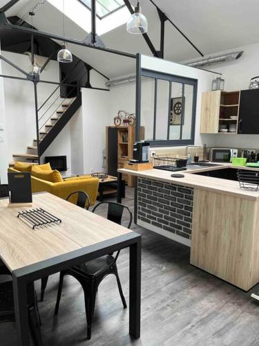 - une cuisine avec des tables et des chaises dans une pièce dans l'établissement Loft relais Cœur de France, à Vierzon