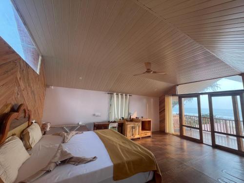 a bedroom with a bed and a large window at DucknChill-Agonda in Agonda