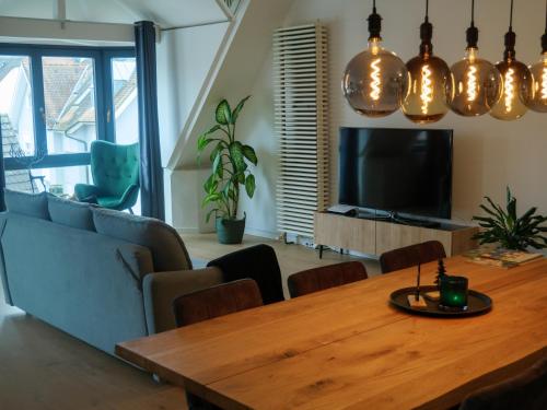 a dining room with a table and a tv at AMAO-Green I 90qm I Zentrum I Maisonette I Dachterrasse I King-Size Boxspringbetten I EuropaPark in Lahr