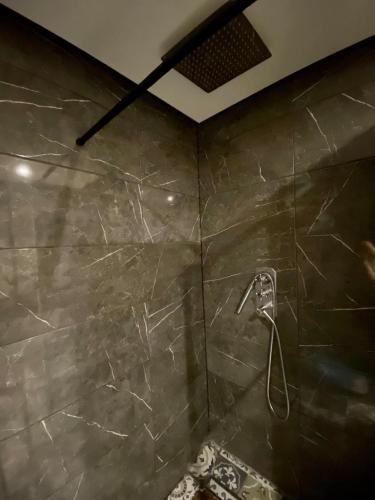 um chuveiro na casa de banho com uma parede em mármore em cozy room in Edinburgh em Edinburgo