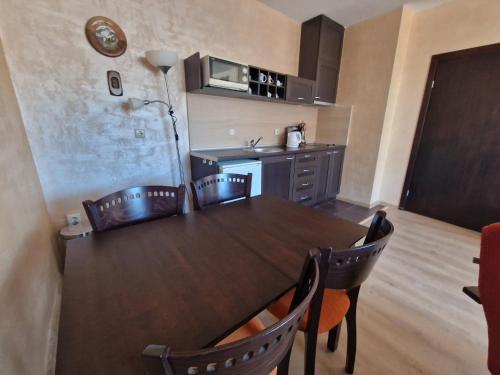 a kitchen with a table and chairs in a room at Bansko Royal Towers Thea Apartment in Bansko