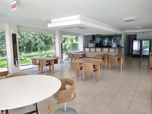 弗洛里亚诺波利斯Suas férias com todo conforto PÉ NA AREIA的餐厅里有桌椅和窗户。
