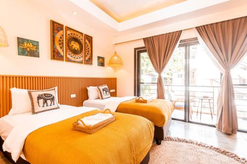 two beds in a room with a balcony at Molly Resorts in Puerto Galera