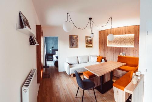 a kitchen and living room with a table and a couch at Apartmány Javorná in Čachrov