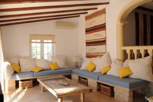 sala de estar con sofá azul y almohadas amarillas en Villa coup de coeur Costa Blanca, en Pedreguer