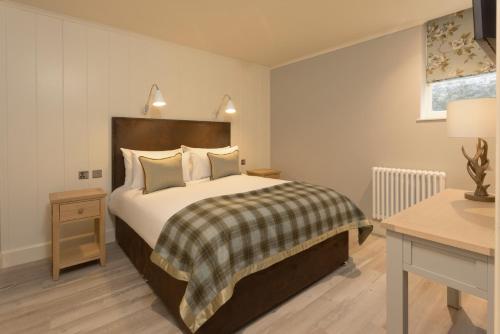 1 dormitorio con 1 cama grande y 1 mesa en The Glencoe Inn, en Glencoe